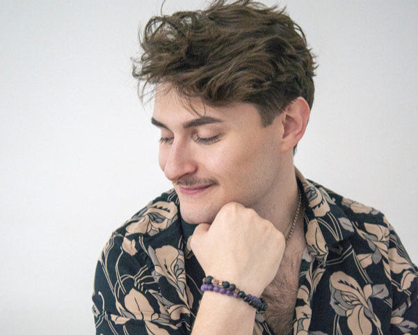 Man wearing a patterned shirt with a neutral background