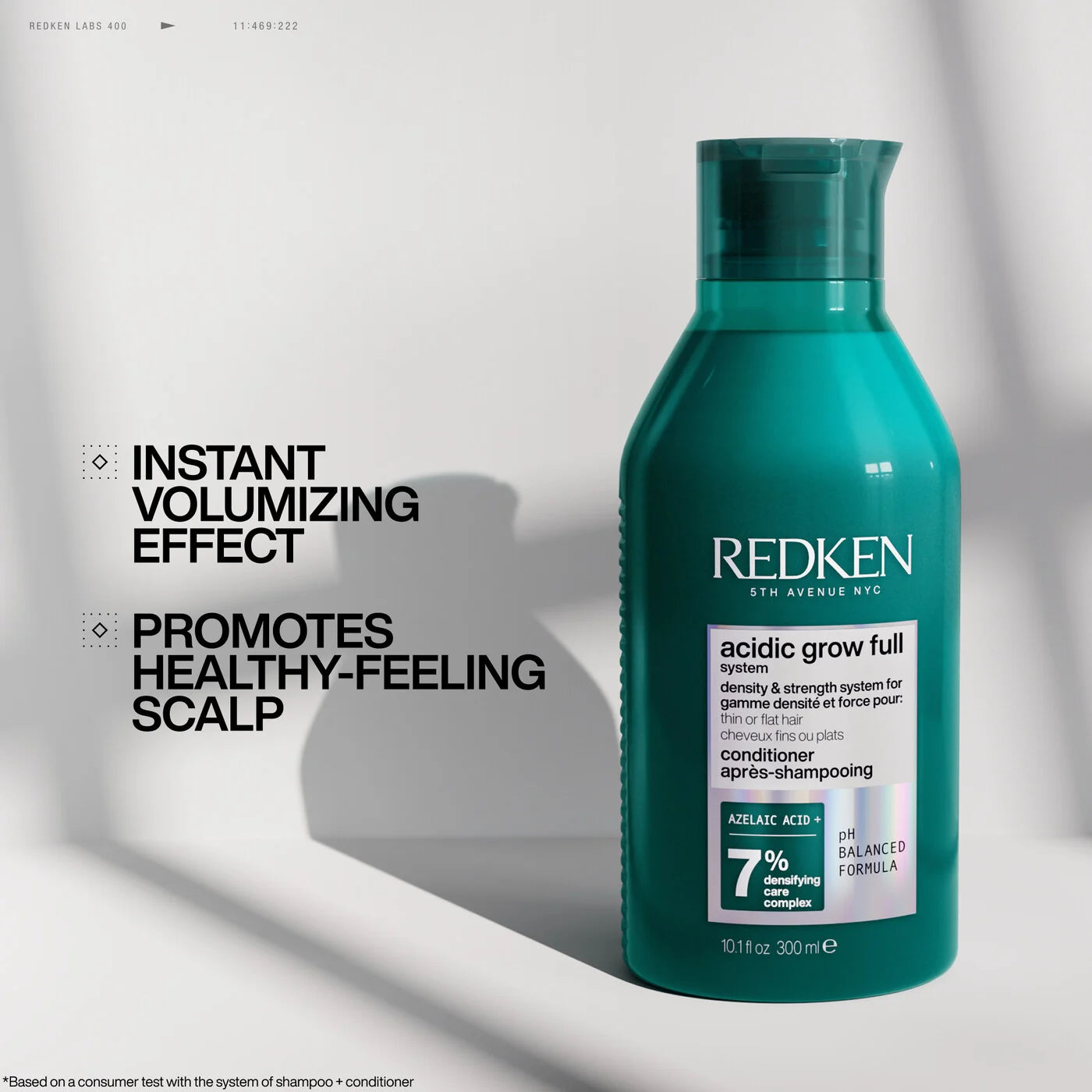 Redken conditioner bottle with text about instant volumizing effect and healthy-feeling scalp on a light background