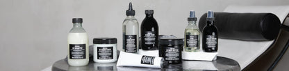 davines oi Collection of skincare and hair care products on a gray surface with a white background bombshell collar city salon and suites troy ny