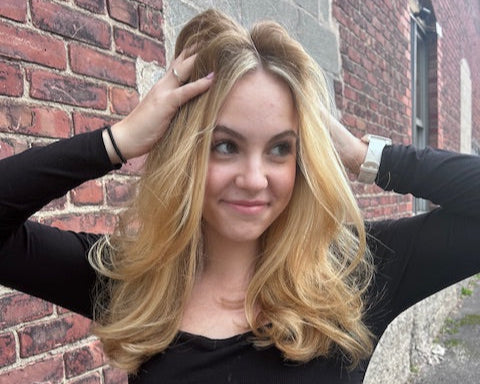 Woman with blonde hair posing on a brick sidewalk